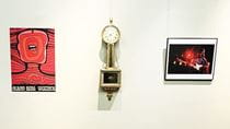 A red Polish poster, a clock and a photograph of Jimi Hendrix on a wall.