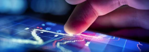A finger using a touchscreen device with images of data on the device screen